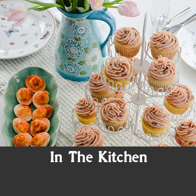 Cupcakes, deviled eggs, and blue pitcher with tulips on a table